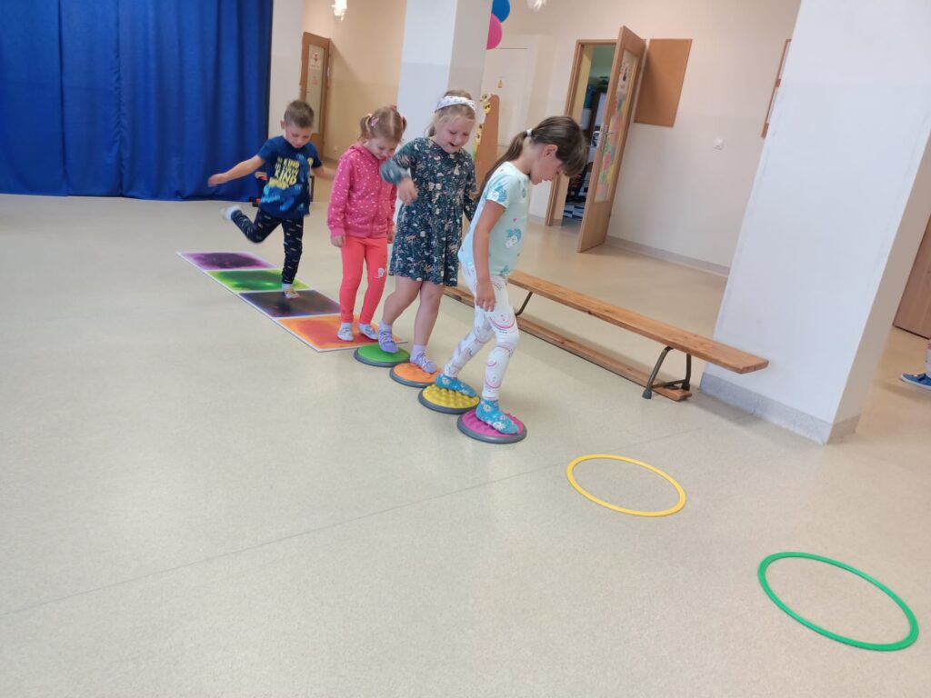 Dzieci ćwiczą na sali gimnastycznej