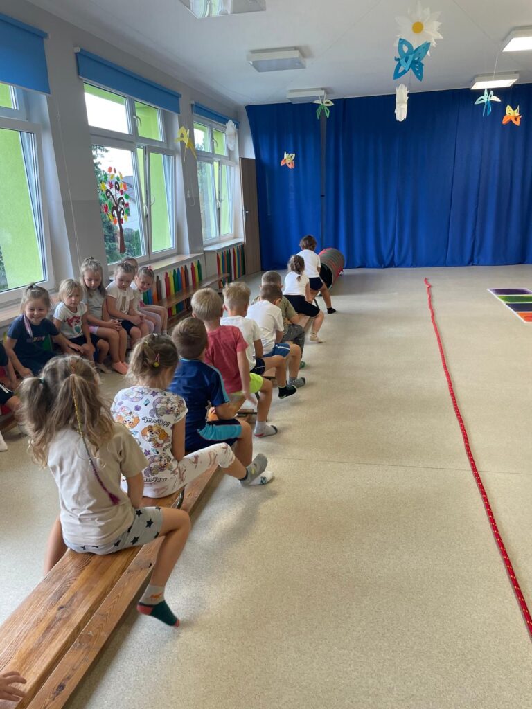 Dzieci ćwiczą na sali gimnastycznej