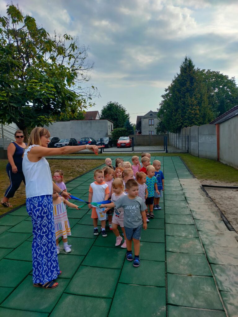 Przedszkolaki spacerują po placu zabaw