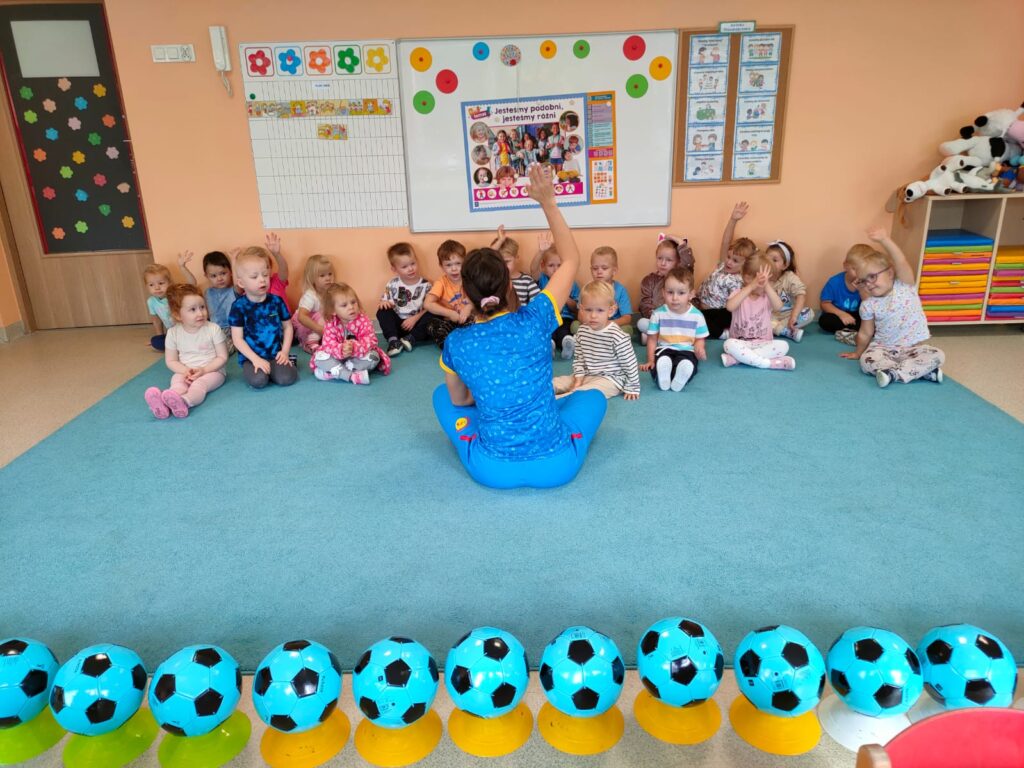 Przedszkolaki ćwiczą na zadjęciach sportowych