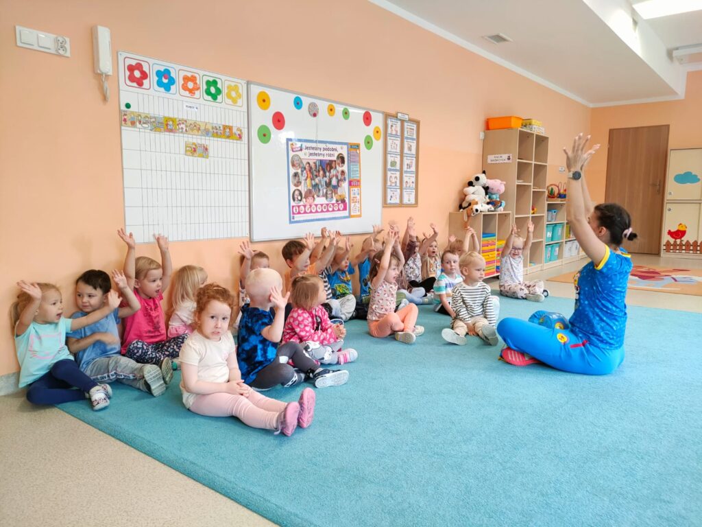 Przedszkolaki ćwiczą na zadjęciach sportowych