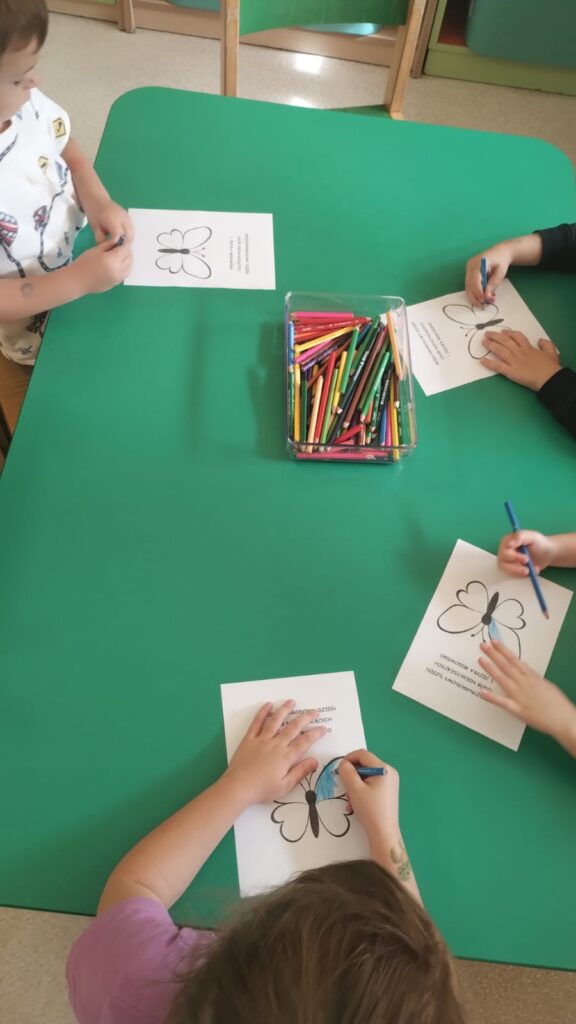 Dzieci kolorują sylwety motylów