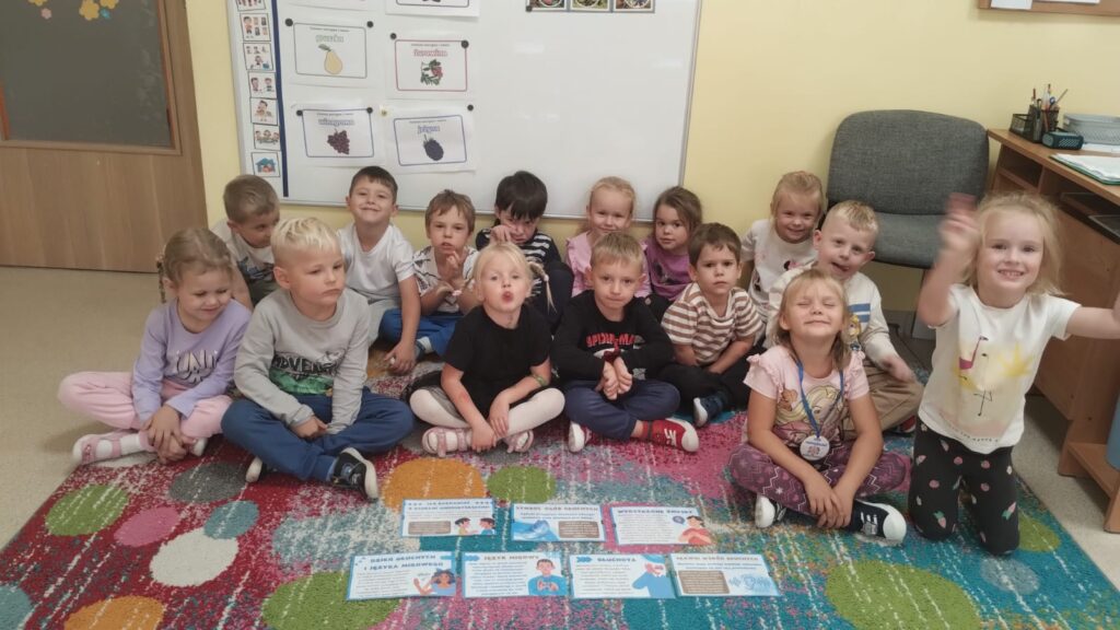Zdjęcie grupowe dzieci siedzą na dywanie
