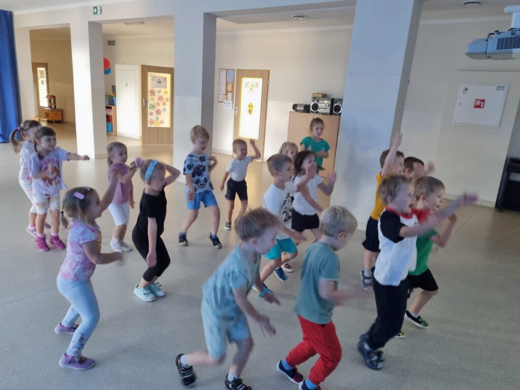 Dzieci ćwiczą na sali gimnastycznej