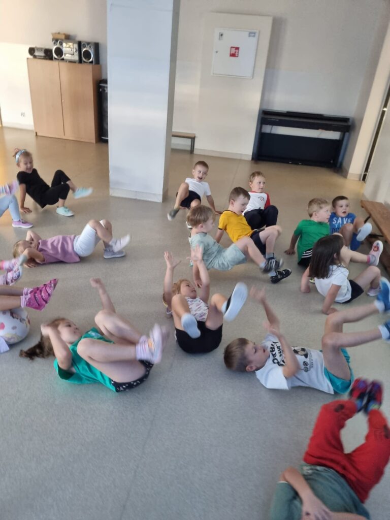 Dzieci ćwiczą na sali gimnastycznej