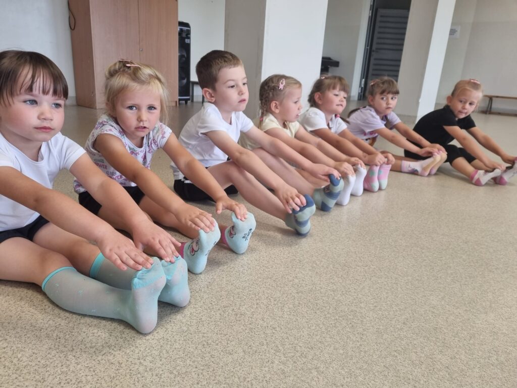 Dzieci ćwiczą na sali gimnastycznej