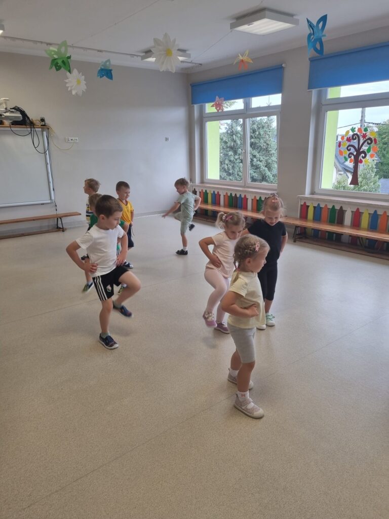 Dzieci ćwiczą na sali gimnastycznej