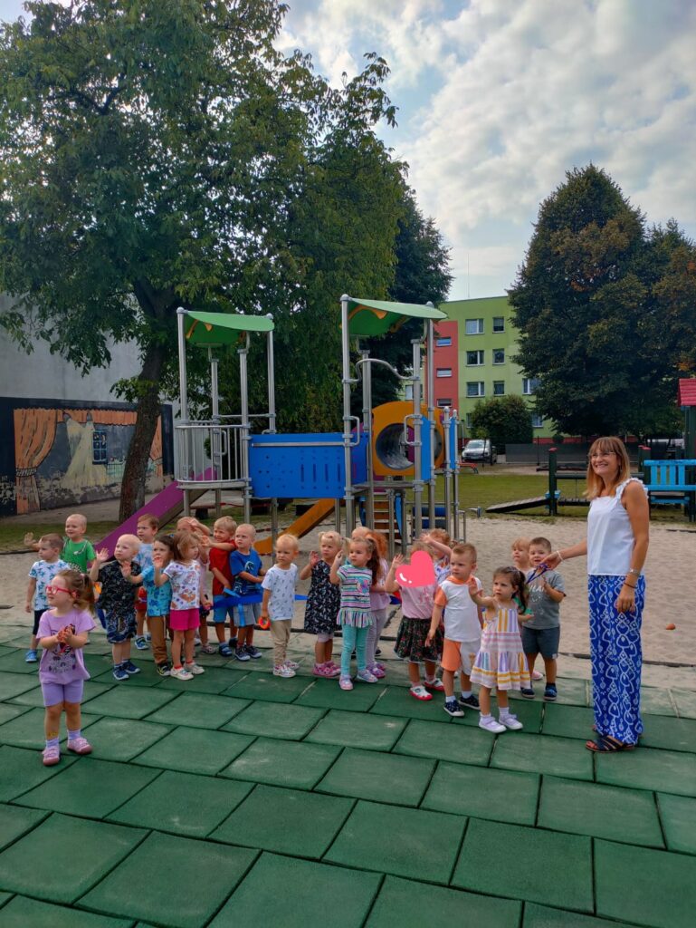 Przedszkolaki spacerują po placu zabawa