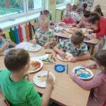Dzieci tworzą kolorowe prace plastyczne, wykorzystując różne kształty makaronu
