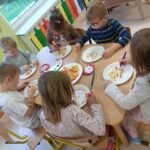 Dzieci tworzą kolorowe prace plastyczne, wykorzystując różne kształty makaronu