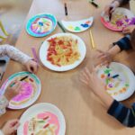 Dzieci tworzą kolorowe prace plastyczne, wykorzystując różne kształty makaronu