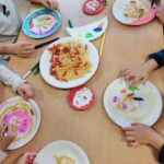 Dzieci tworzą kolorowe prace plastyczne, wykorzystując różne kształty makaronu