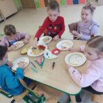 Dzieci tworzą kolorowe prace plastyczne, wykorzystując różne kształty makaronu