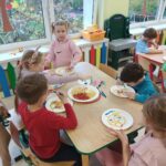 Dzieci tworzą kolorowe prace plastyczne, wykorzystując różne kształty makaronu