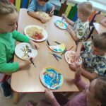 Dzieci tworzą kolorowe prace plastyczne, wykorzystując różne kształty makaronu