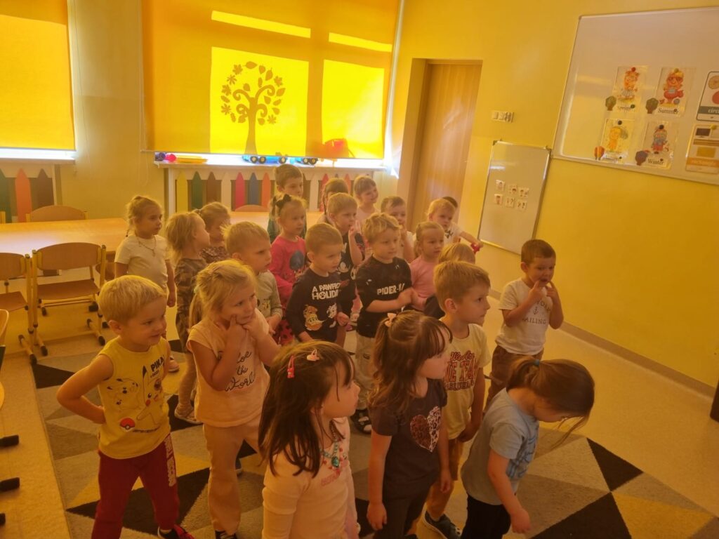 Dzieci wykonują ćwiczenia przy tablicy multimedialnej