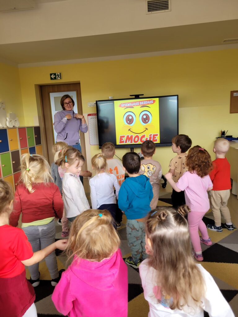 Dzieci wykonują ćwiczenia przy tablicy multimedialnej