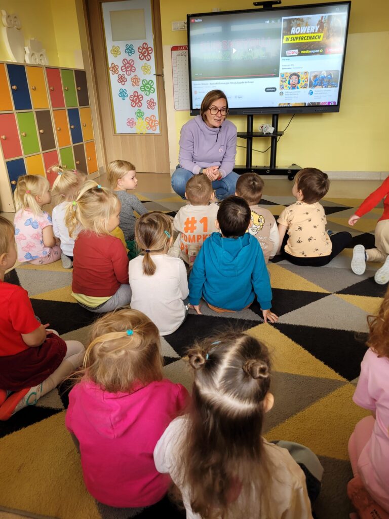Dzieci wykonują ćwiczenia przy tablicy multimedialnej