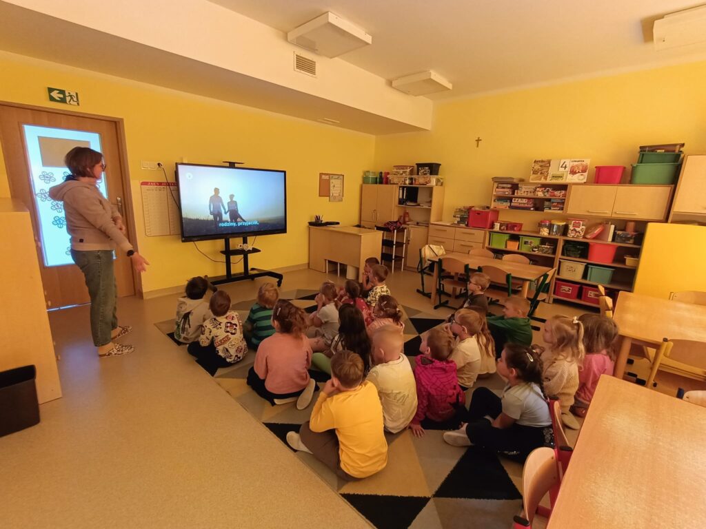 Dzieci wykonują ćwiczenia przy tablicy multimedialnej