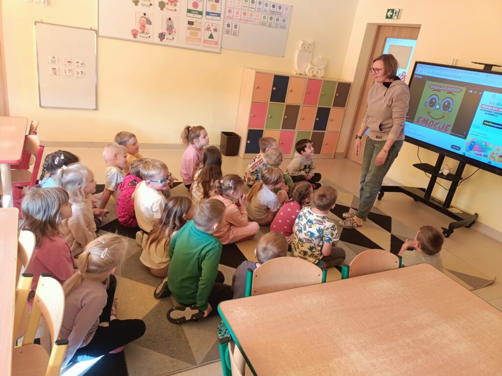 Dzieci oglądają film na tablicy multimedialnej