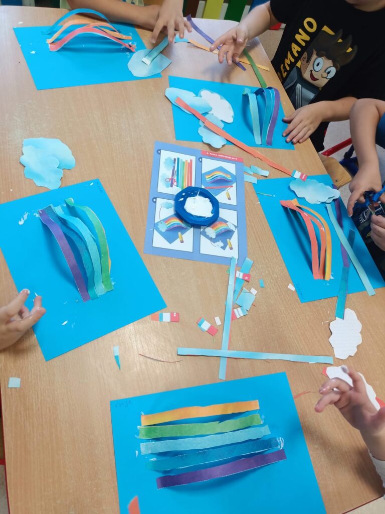 Przedszkolaki tworzą pracę plastyczną - tęczę