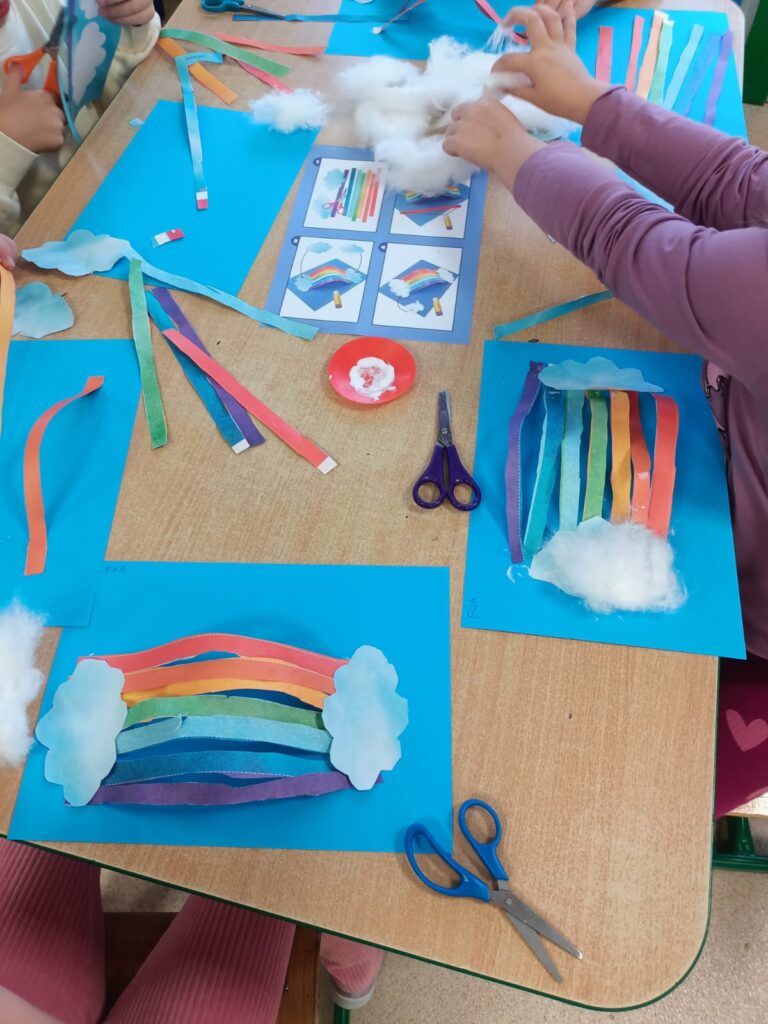 Przedszkolaki tworzą pracę plastyczną - tęczę