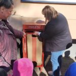 Pracownicy poczty pokazują dzieciom, jak korzystać ze skrzynki na listy