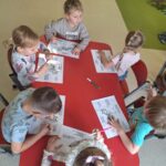 Dzieci porównują swoją dłoń z łapą wilka