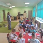 Dzieci oglądaja ilustracje wilka