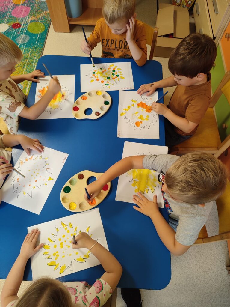 Przedszkolaki malują sylwetę liścia.