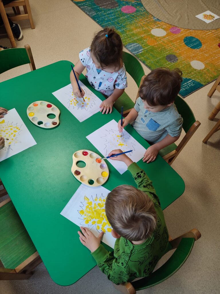 Przedszkolaki malują sylwetę liścia.