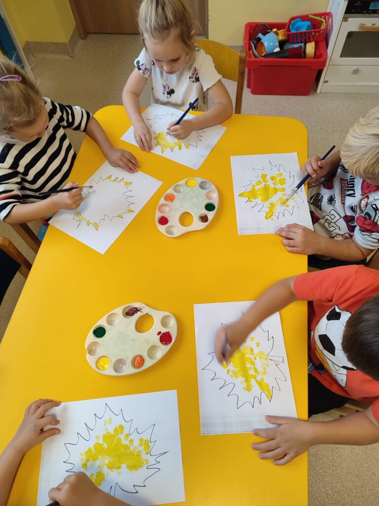 Przedszkolaki malują sylwetę liścia.