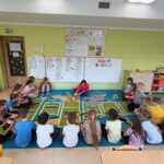 Dzieci układają z kredek różne kształty, tworząc proste kompozycje