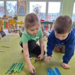 Dzieci układają kredki kolorami