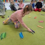 Dzieci układają kredki kolorami