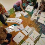 Dzieci układają z kredek różne kształty, tworząc proste kompozycje