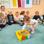 Dzieci sortują kredki, dopasowując ich kolory do odpowiednich kubeczków