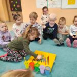 Dzieci sortują kredki, dopasowując ich kolory do odpowiednich kubeczków