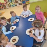 Dzieci prezentują samodzielnie przygotowaną przekąskę w formie "jadalnego misia"