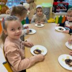 Dzieci prezentują samodzielnie przygotowaną przekąskę w formie "jadalnego misia"