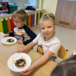 Dzieci prezentują samodzielnie przygotowaną przekąskę w formie "jadalnego misia"