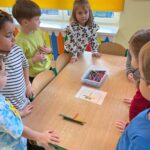 Dzieci układają z kredek różne kształty, tworząc proste kompozycje