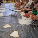 Dzieci z grupy Słoneczka w trakcie zabawy sensorycznej- misie z mąki