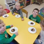 Dzieci prezentują samodzielnie przygotowaną przekąskę w formie "jadalnego misia"