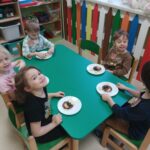 Dzieci prezentują samodzielnie przygotowaną przekąskę w formie "jadalnego misia"