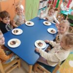 Dzieci prezentują samodzielnie przygotowaną przekąskę w formie "jadalnego misia"