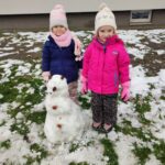 Dzieci lepią ze śniegu bałwana
