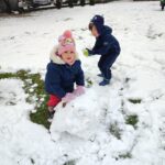 Dzieci lepią ze śniegu bałwana