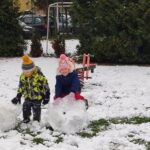 Dzieci lepią ze śniegu bałwana