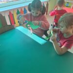 Dzieci w trakcie wycinania choinek z papieru
